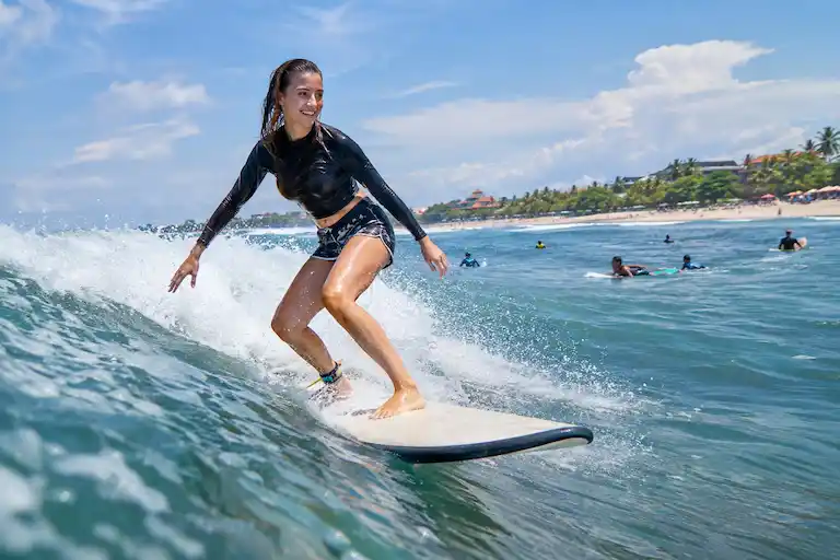 Sunlit Surfer Riding a Coastal Wave